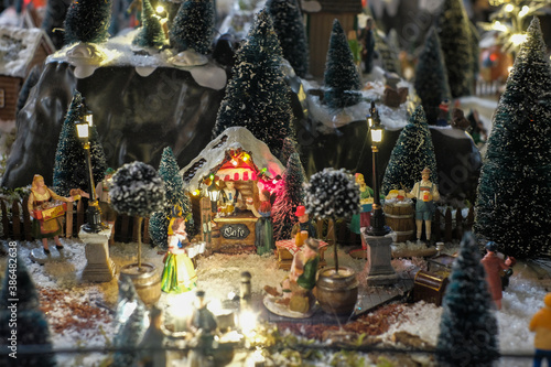 Miniature of winter scene with Christmas houses, people, trees, Christmas concept.