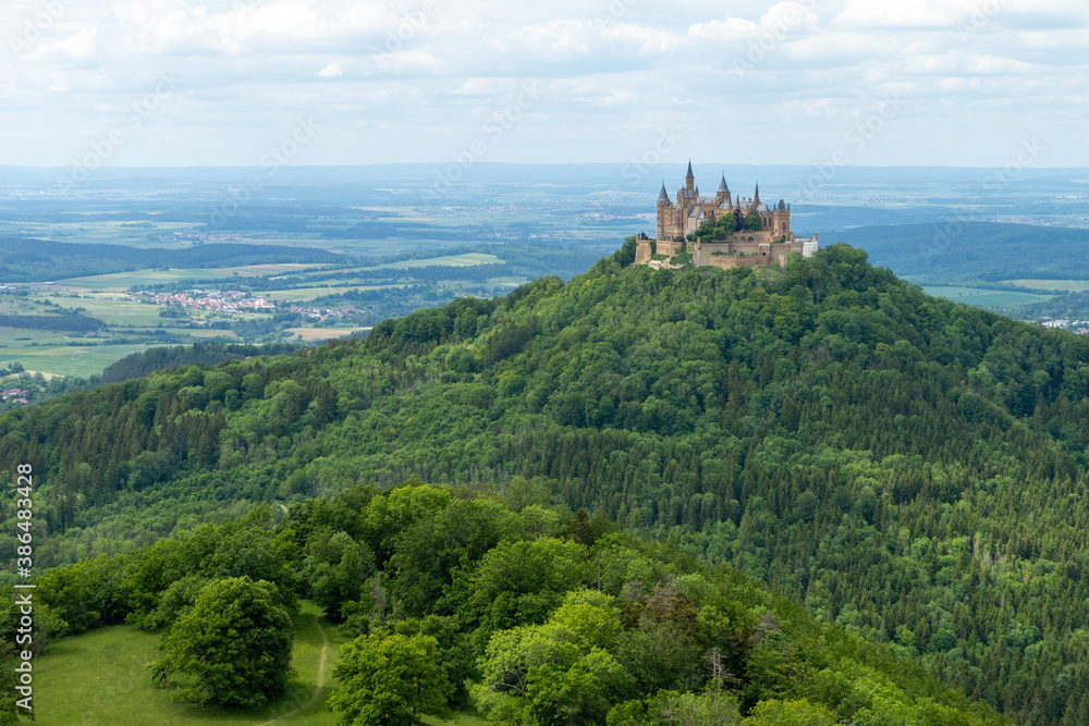 View of Hohenzollern castle on a green hill against sky in the background