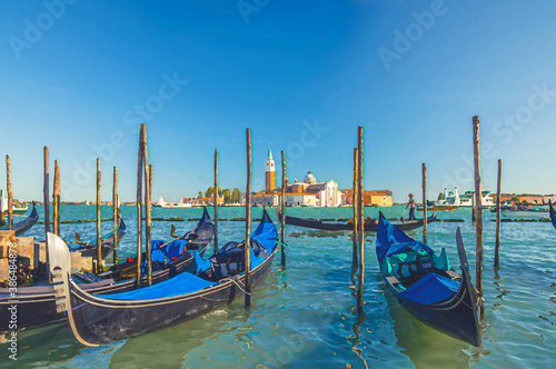Watercolor drawing of Gondolas moored docked on water in Venice. Gondoliers sailing San Marco basin waterway. San Giorgio Maggiore island with Campanile San Giorgio in Venetian Lagoon
