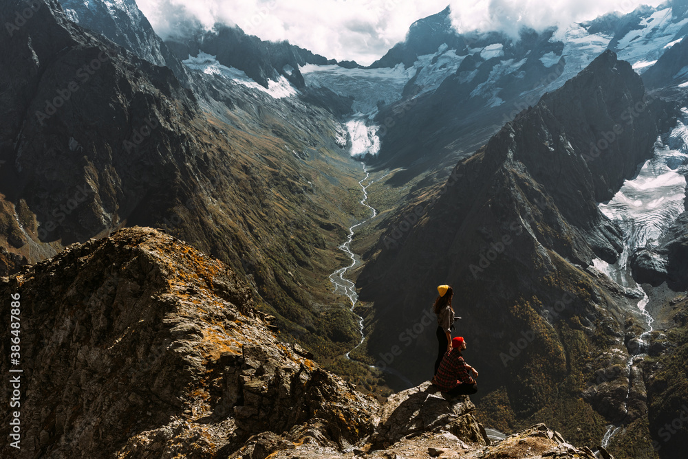 The couple travels through the Caucasus mountains. Couple in love in the Caucasus mountains. Man and woman traveling. A walk in the mountains. Hiking in the mountains. Panorama. Copy space