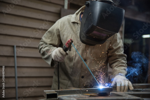 welder is welding metal in workshop