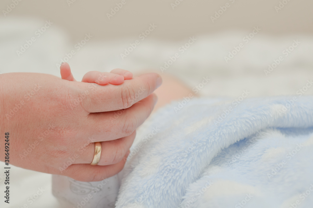mom is holding her baby's hand mom is holding her baby's hand