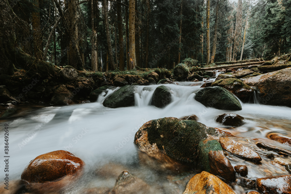 Small waterfall and river rapids. Mountain river in autumn forest. Long exposure photo of river. Small waterfall and river rapids. Mountain river in autumn forest. Long exposure photo of river.