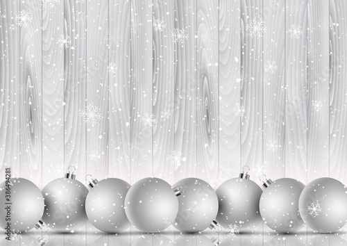 Christmas baubles on a snowflake and wooden background
