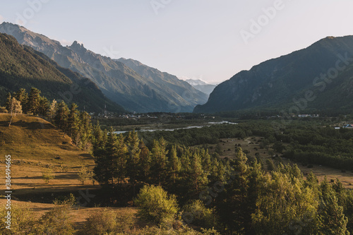Landscape with valley in mountains. Rural scene of autumn trees and rivers. Ecotourism and hiking in mountains.