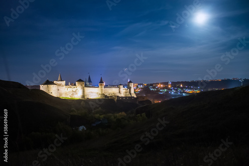 Panoramic  night view of ancient fortress castle in Kamianets-Podilskyi, Khmelnytskyi Region, Ukraine. Old ?astle photo on a postcard or cover. Long exposive photo