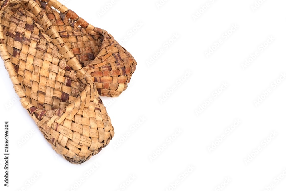 Ancient national shoes woven from bark of tree and hemp isolated on white background