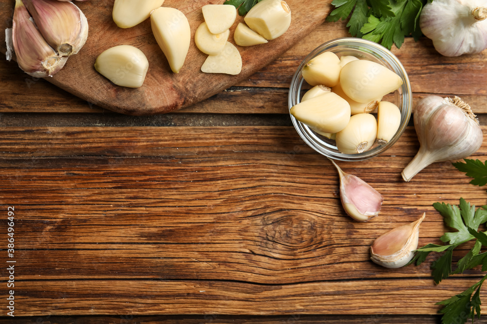 Flat lay composition with fresh garlic bulbs and cloves on wooden table, space for text. Organic product Flat lay composition with fresh garlic bulbs and cloves on wooden table, space for text. Organic product