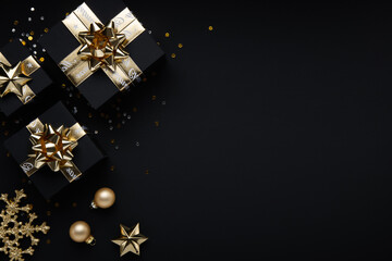 Merry Christmas and Happy Holidays greeting card, frame, banner. New Year. Noel. Christmas ornaments and gifts on black background top view. Winter xmas holiday theme. Flat lay	
