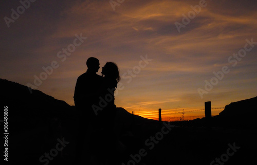 silhouette of a couple with sunsets behind