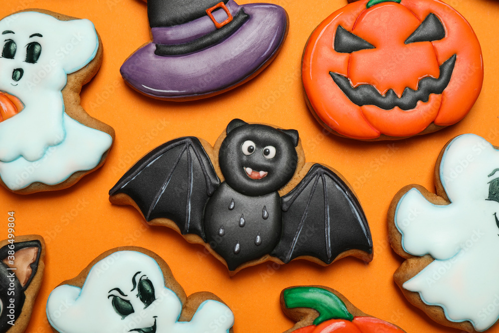 Different decorated gingerbread cookies on orange background, flat lay. Halloween celebration - obrazy, fototapety, plakaty 