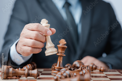 Businessman moving chess piece on chess board game concept for ideas and competition and strategy, business success concept, business competition planing teamwork strategic concept.