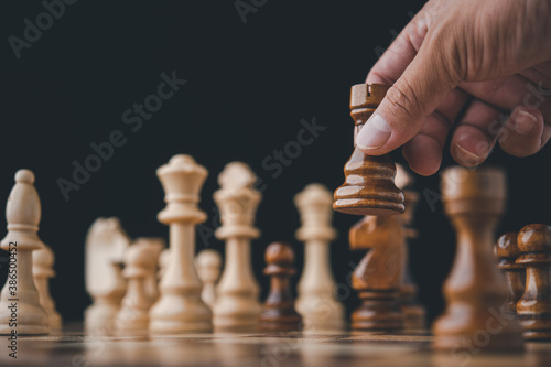 male hand moving chess piece on chess board game concept for ideas and competition and strategy, business success concept, business competition planing teamwork strategic concept.