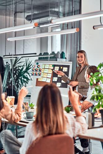 Bilde på lerret Group of positive multicultural marketing experts planning working process and sharing ideas while creating advertising campaign