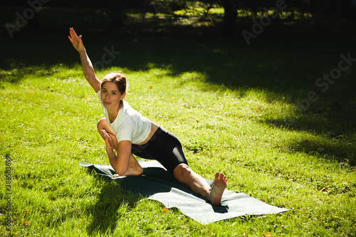 Yoga asanas in nature. Yoga poses everyday. Practicing young woman. Yoga in park. photo