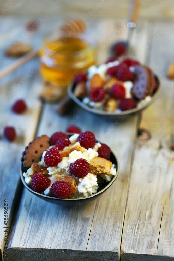 Selective focus. A healthy dessert with mascarpone cheese, biscuits and raspberries. Selective focus. A healthy dessert with mascarpone cheese, biscuits and raspberries.
