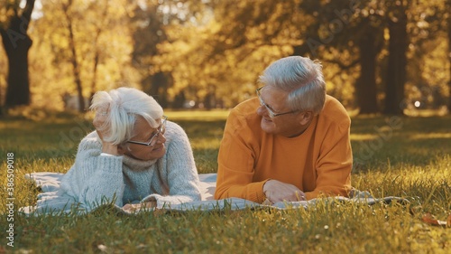 Wellbeing concept. Portrait of happy senior retired couple relaxing in autumn park. High quality photo