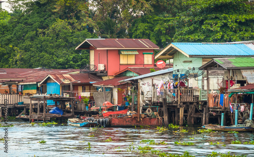 Obraz na płótnie Stilt Houses at a Klong in Bangkok, Thailand. Chao Phraya Riverbank with Lush Vegetation. w salonie