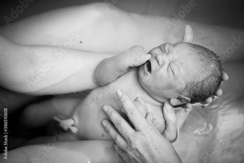 Behang Mother Holding Newborn Baby in Birthing Pool After Home Birth