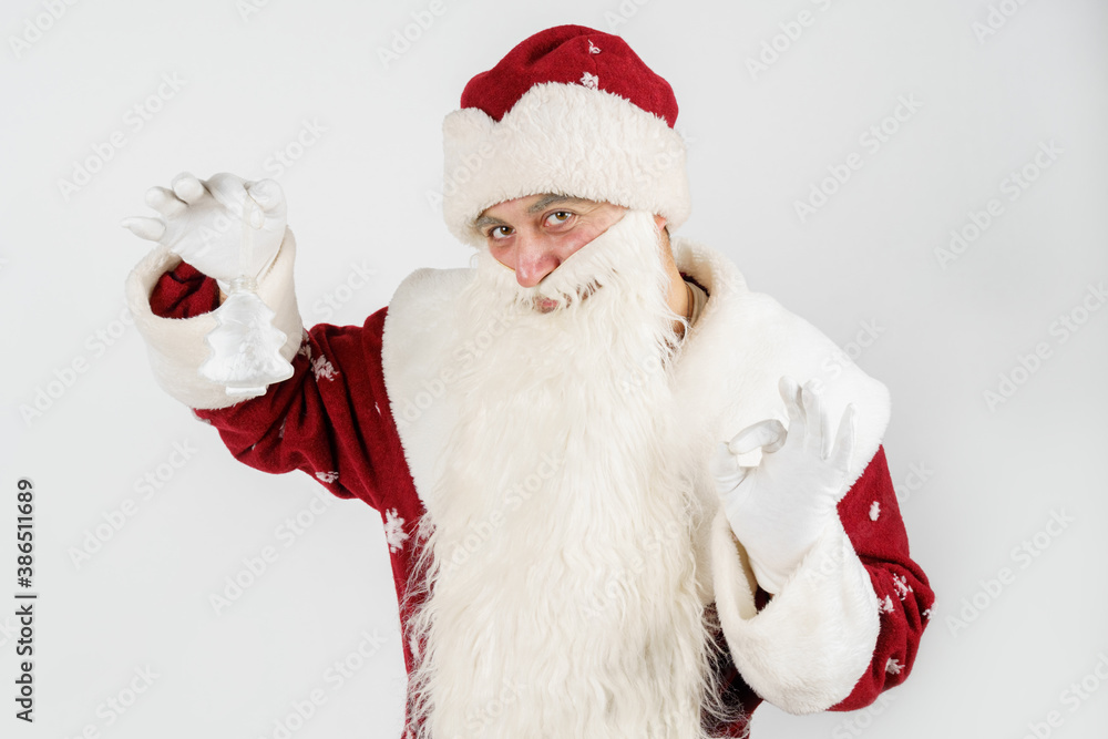 Santa Claus holds a Christmas tree toy in his hands. Isolated on white Santa Claus holds a Christmas tree toy in his hands. Isolated on white