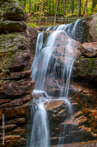 Flowing waterfall in the middle of rocks in the forest