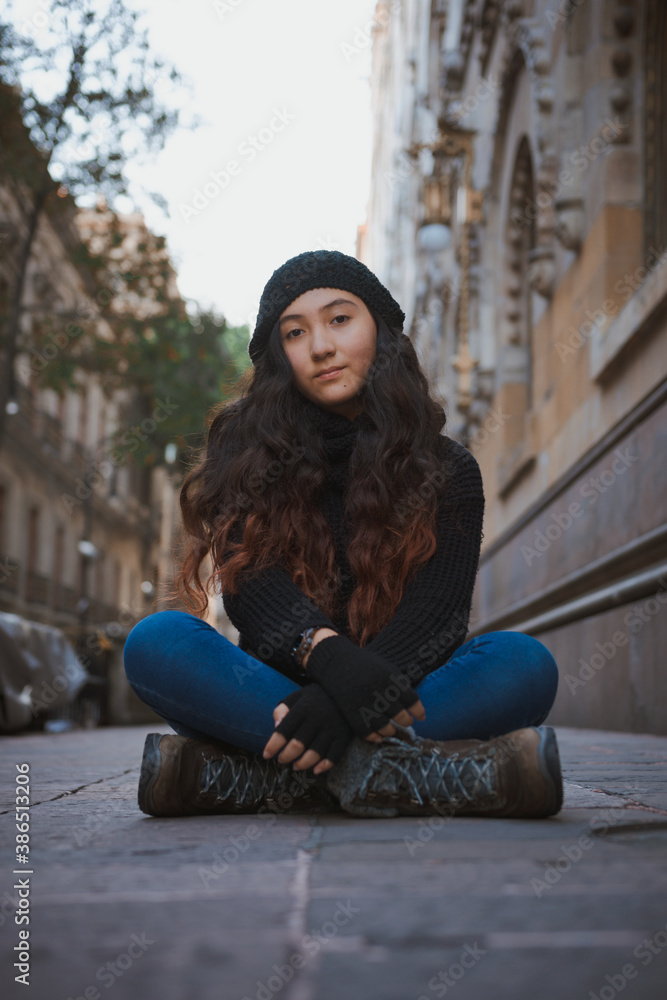 Adolescente sentada en las calles de la Ciudad de México en una tarde de  otoño, niña bonita posando sentada con ropa de abrigo, tarde fría de  Octubre en la calle Stock Photo
