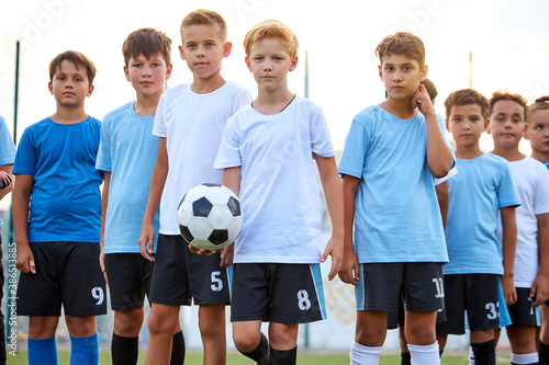 portrait of sportive boys with ball, they have competition in stadium. soccer, football, sport concept