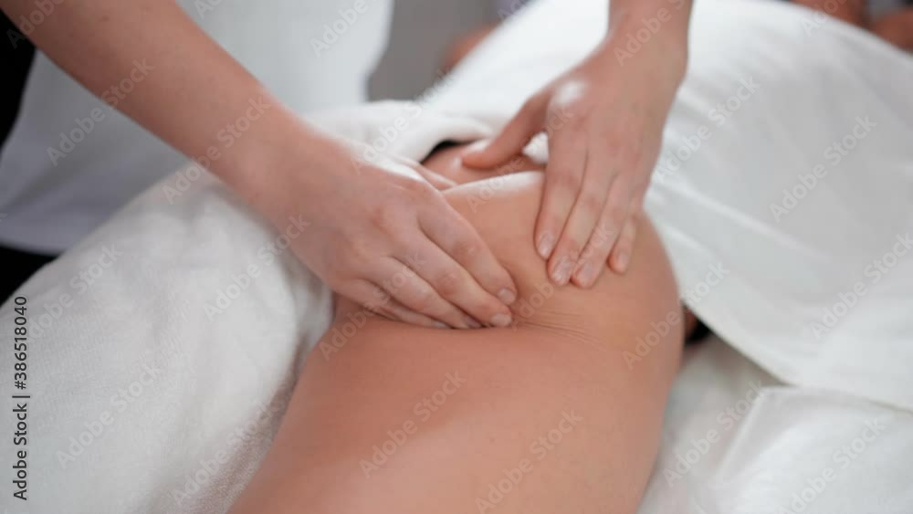 A woman massage therapist makes a powerful anti-cellulite massage of the buttocks to a female client in a cosmetic clinic. Skin care concept. Healthcare and medicine A woman massage therapist makes a powerful anti-cellulite massage of the buttocks to a female client in a cosmetic clinic. Skin care concept. Healthcare and medicine