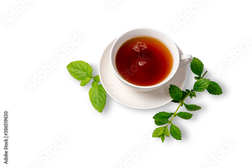 A Cup of black tea on a saucer with mint leaves on a white isolated background. Space for copying.