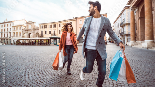 Photography Happy couple of tourists walking in the city holding shopping bags - Boyfriend a