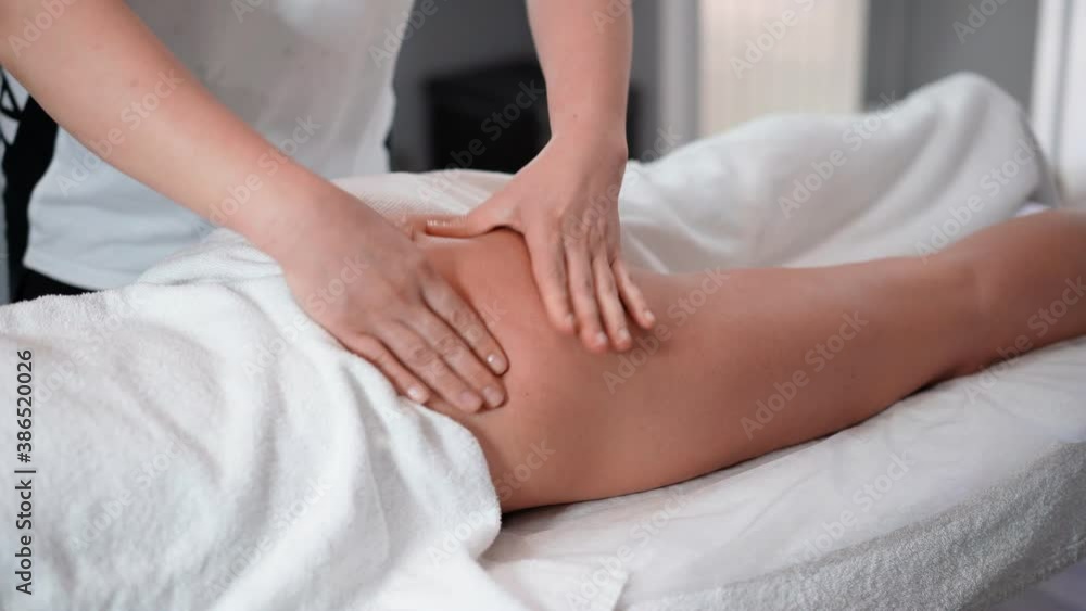 A woman masseur therapist makes a powerful anti-cellulite massage of the buttocks and legs to a female client in a cosmetic clinic. Perfect skin fat burning beauty concept. Healthcare and medicine A woman masseur therapist makes a powerful anti-cellulite massage of the buttocks and legs to a female client in a cosmetic clinic. Perfect skin fat burning beauty concept. Healthcare and medicine