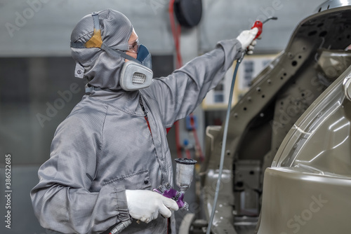 An employee of the paint shop prepares the car body for painting