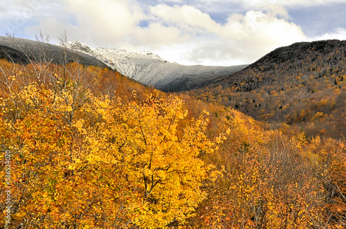 Brilliant autumn leaves and early dusting of snow on summit of Mount Lafayette in Franconia Notch State, New Hampshire. photo