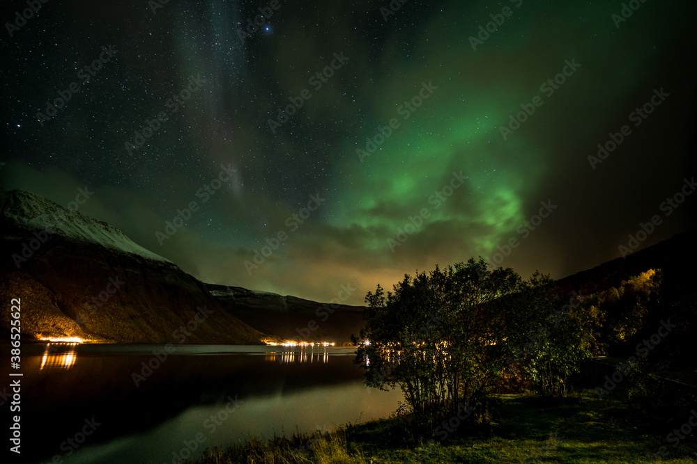Nothern Lights in Norway over a Fjord and a snowy Mountain 