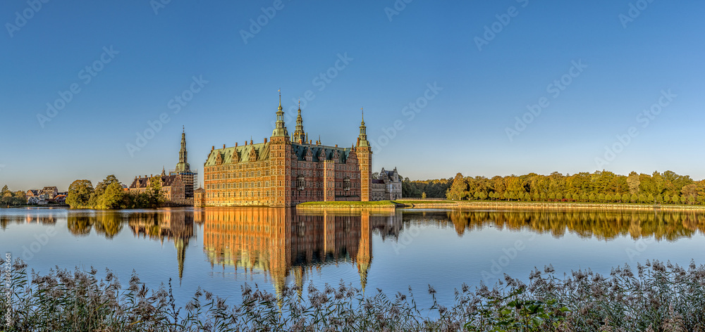 Panoramic view of Frederiksborg Castle in a mirror-gloss reflection at surise