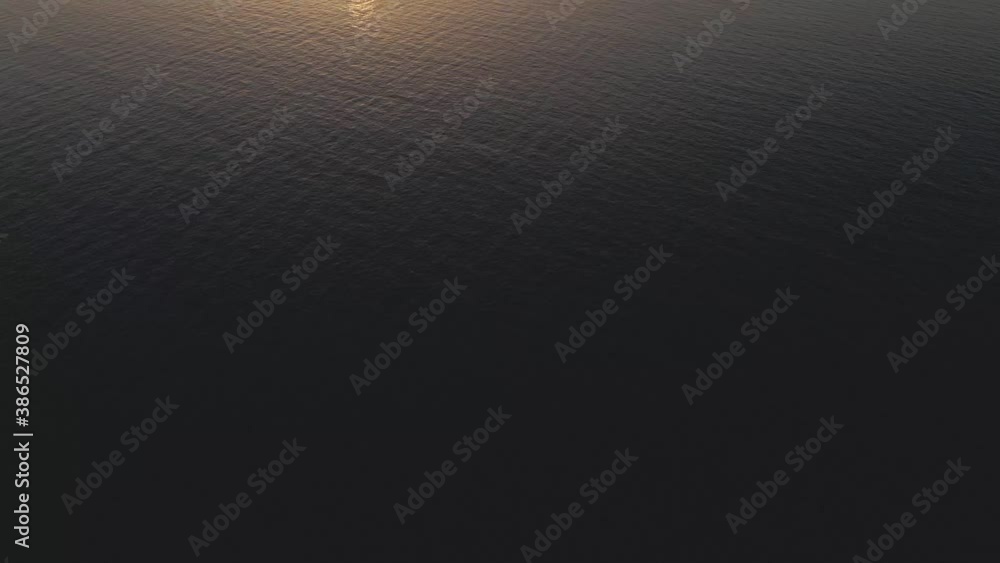 Sunrise/Sunset view over the ocean with woman standing in water Sunrise/Sunset view over the ocean with woman standing in water