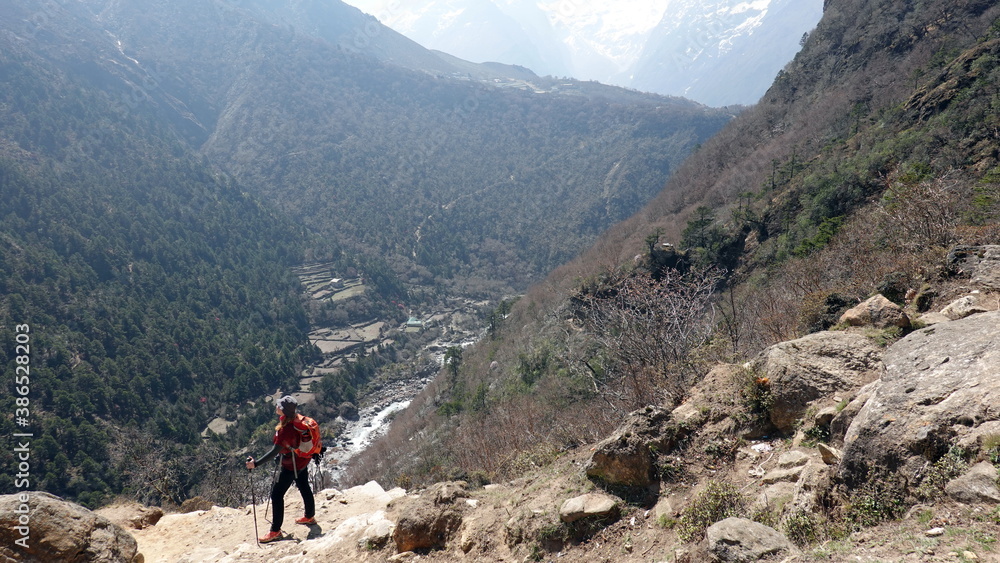 Backpacker woman hiking and trekking in the Nepal mountains around Everest.