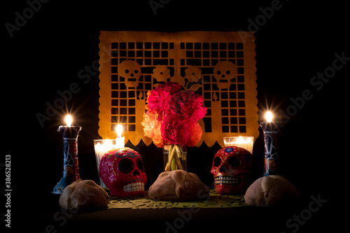 Day of the Dead offering from central Mexico with papel picado, veladoras, photography, flowers and bread of the dead