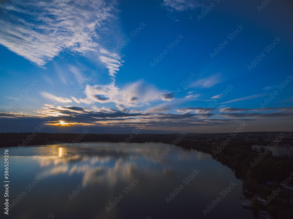 Obraz premium Sunset over a river with forest on a horizon. Almost dusk.