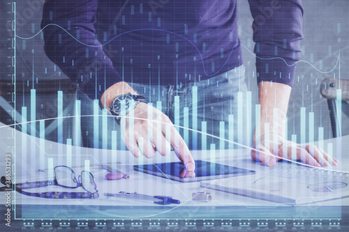 Double exposure of man s hands holding and using a digital device and forex graph drawing. Financial market concept.