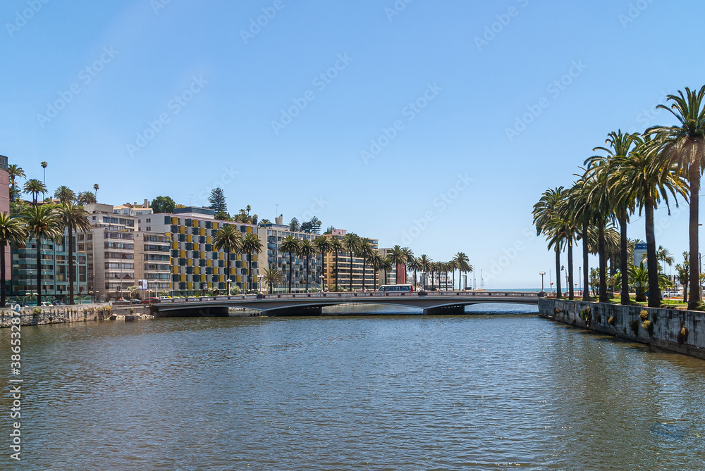 Vina Del Mar, Chile - December 8, 2008: Landscape of South Shore of the estuary with luxury tall buildings and row of mature palm trees under blue sky. Bridge with bus.