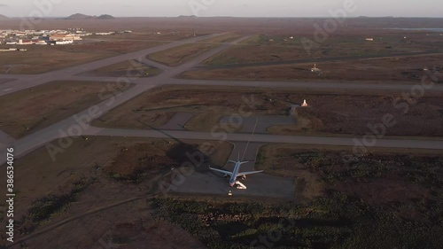 Lone Boeing 757 airplane parked on tarmac in open field in Iceland, aerial photo