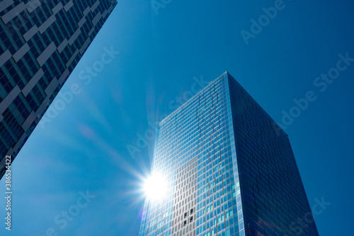 高層ビルの壁面に反射する太陽の光