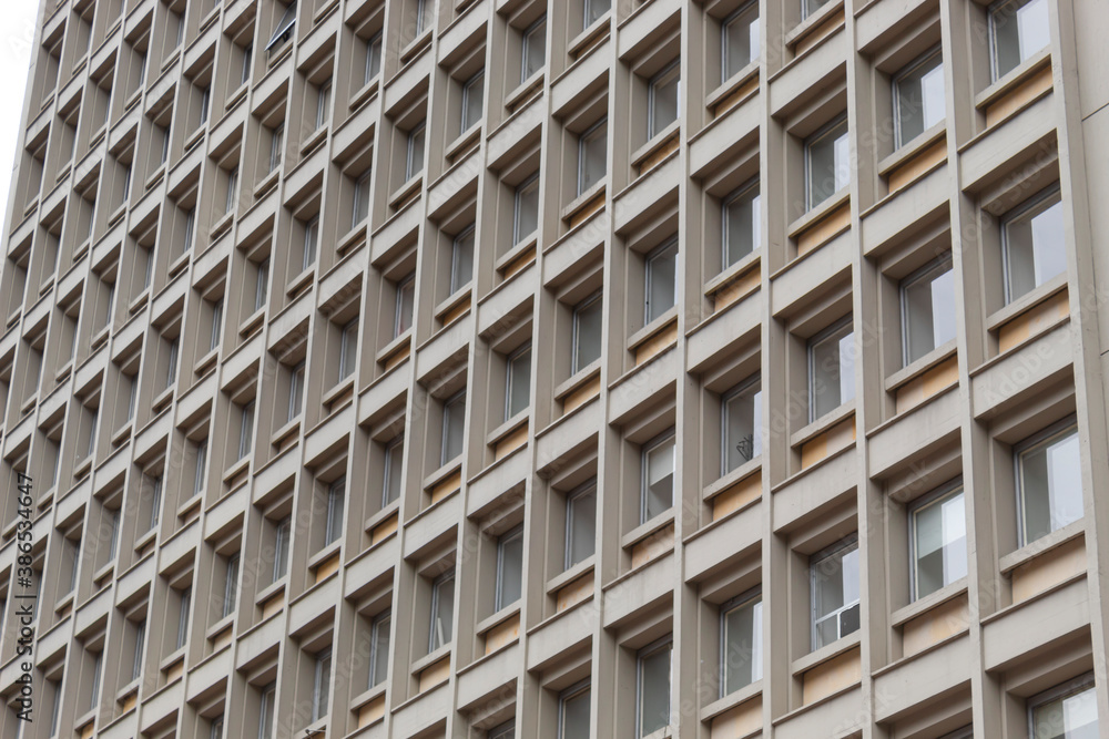 Windows and square patterns of an old skyscraper. Architecture details and symmetry concept Windows and square patterns of an old skyscraper. Architecture details and symmetry concept
