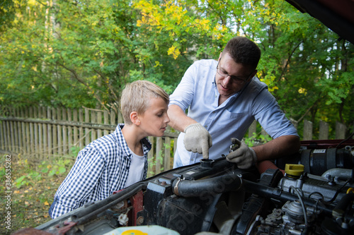 Father teaching his son how to repair the car