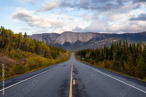 View of Scenic Road surrounded by Trees and Rocky Mountains on a Cloudy Fall Day in Canadian Nature. Taken near Whitehorse, Yukon, Canada. © edb3_16