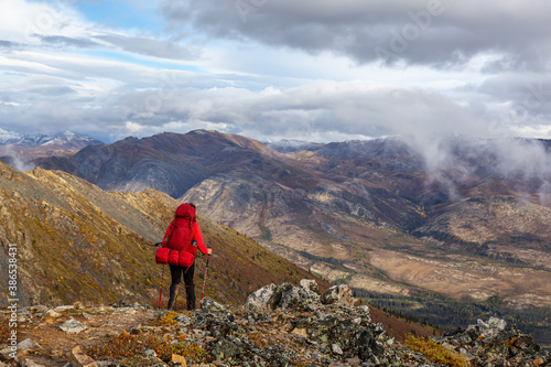 Woman Backpacking along Scenic Hiking Trail surrounded by Mountains in Canadian Nature. Taken in Tombstone Territorial Park, Yukon, Canada. © edb3_16