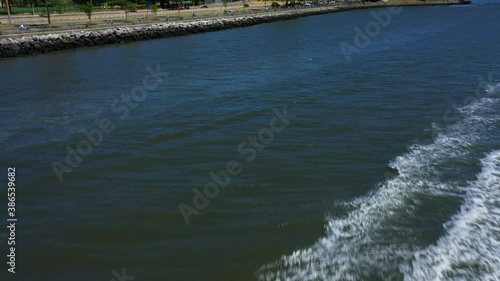 Wallpaper Mural An aerial view of a couple riding on a red jet ski. It races towards the drone camera which dolly in & over the craft and the wake behind. It is a sunny day on the waters of Lower New York Bay. Torontodigital.ca
