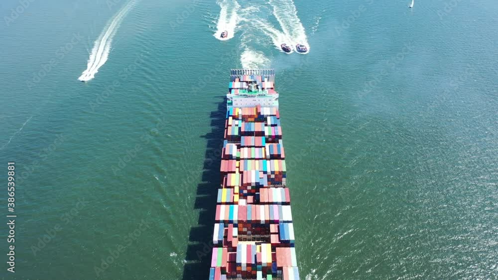 An aerial shot of a cargo ship with colorful containers onboard. The