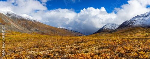 Beautiful Panoramic View of Scenic Valley surrounded by Snowy Mountains in Canadian Nature. Season change from Fall to Winter. Taken near Grizzly Lake in Tombstone Territorial Park, Yukon, Canada.